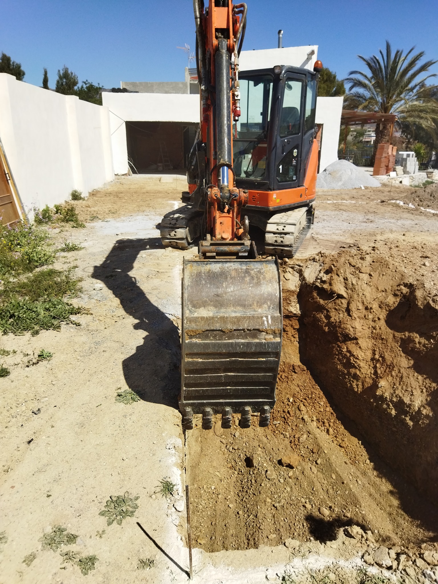 Miniexcavadora Doosan abriendo zanja inicial para la piscina