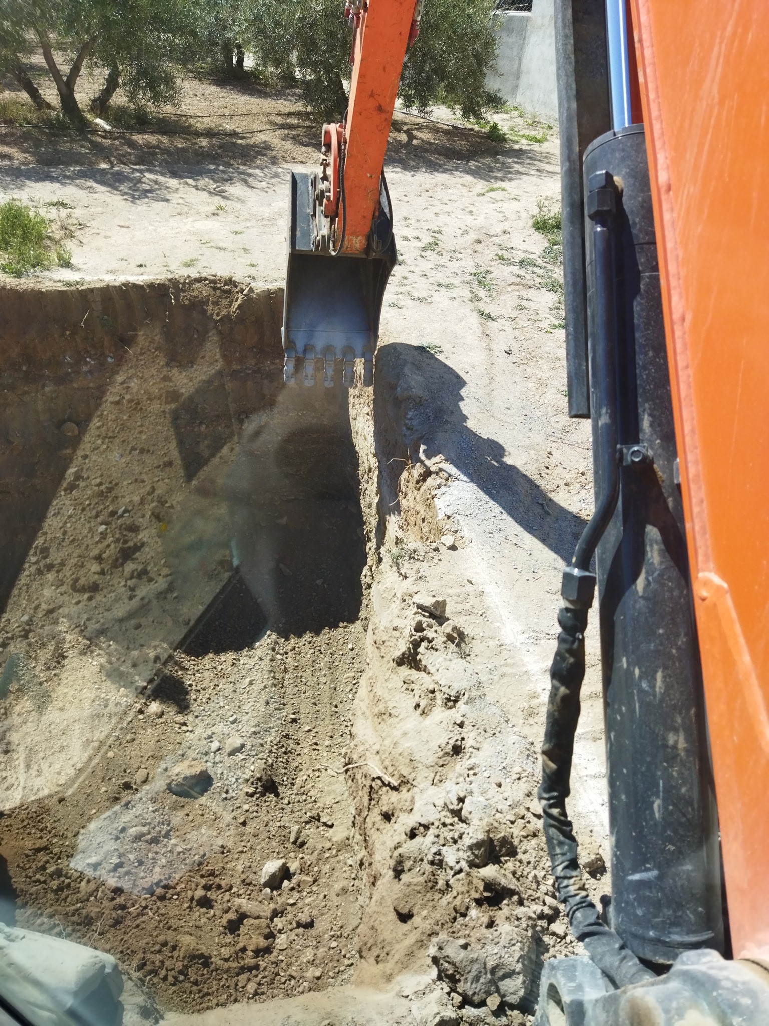 Detalle del cazo hidráulico extrayendo tierras del vaso de la piscina