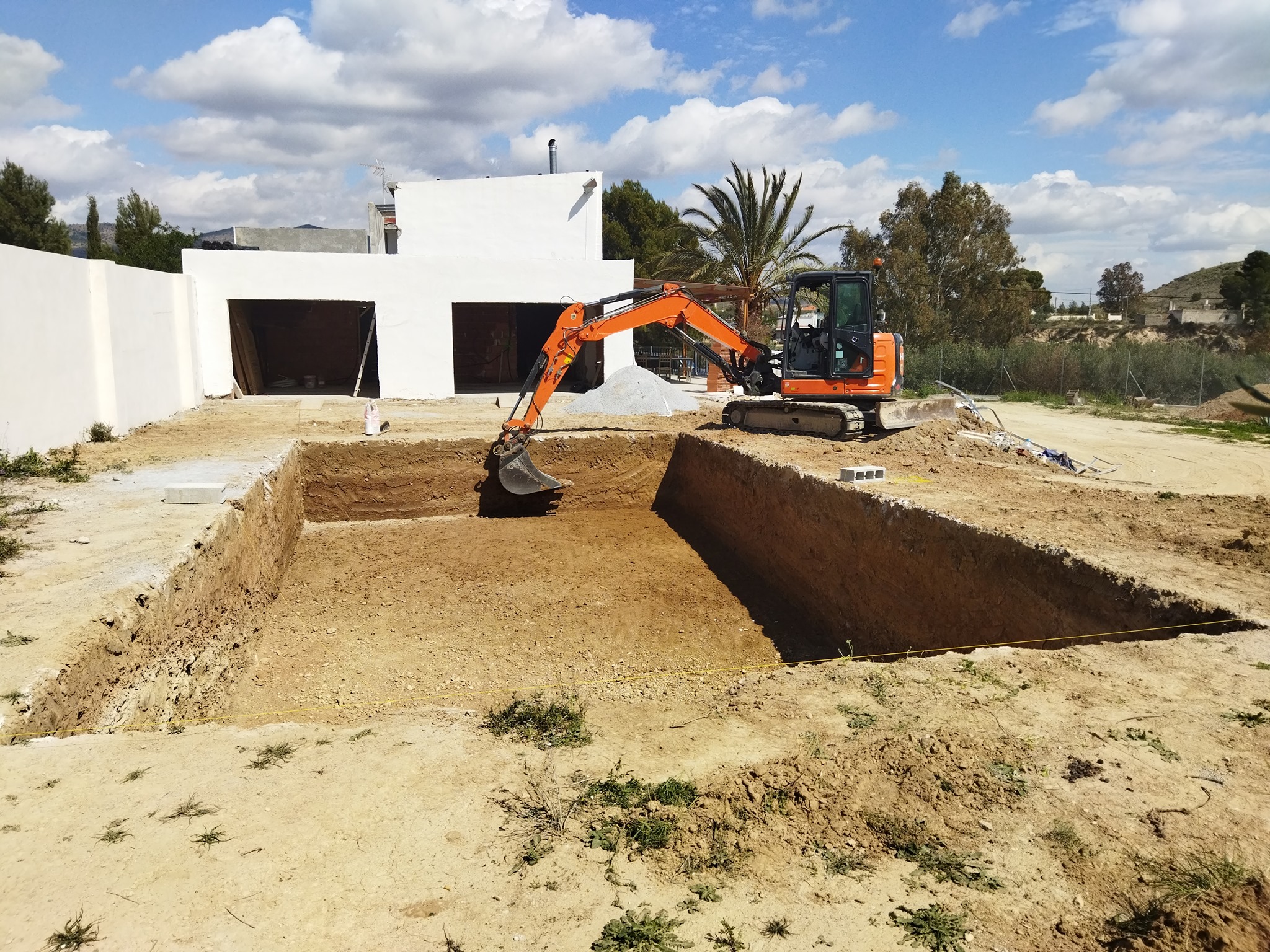 Excavación para piscina residencial en chalet blanco con palmera en Almería, ejecutada por Excavaciones Tripiana