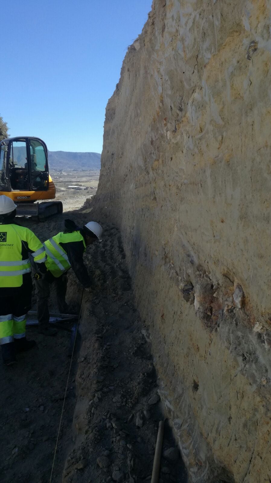 Operarios replanteando el rebaje con cinta métrica junto a miniexcavadora JCB 8050 en Tíjola