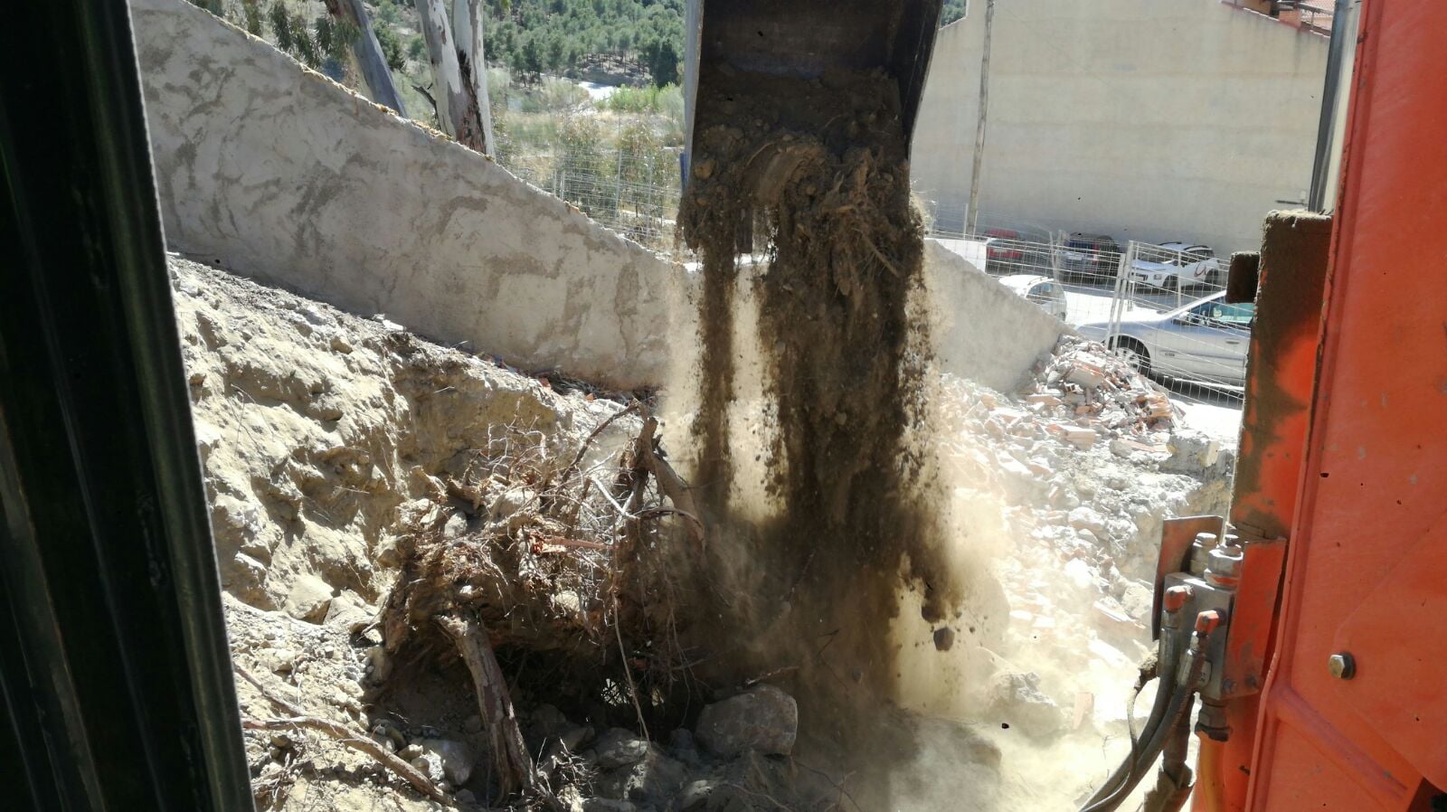 Excavadora cargando dumper con tierras y raíces durante el rebaje en Tíjola