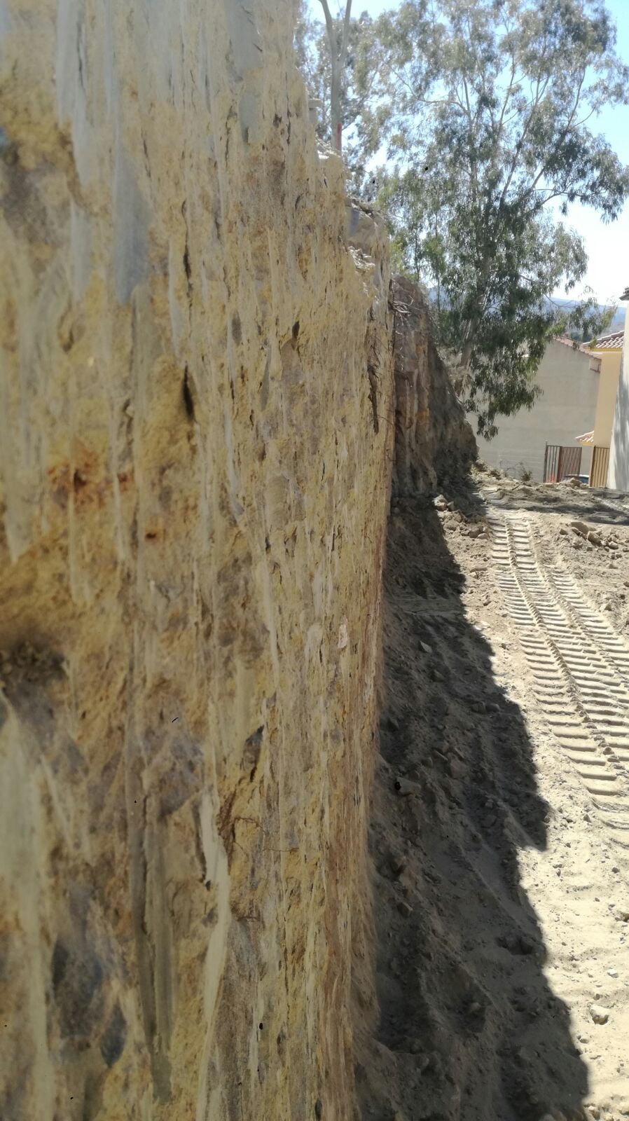 Talud vertical terminado con huellas de cadenas en el suelo del rebaje